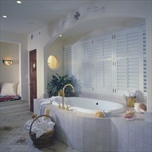 Tub with tile surround set in arched alcove with shuttered windows