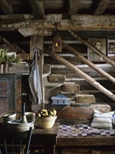 Rustic stairs descending into kitchen area in restored log home