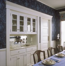 A built in china cabinet and buffet in a restored Victorian dining room