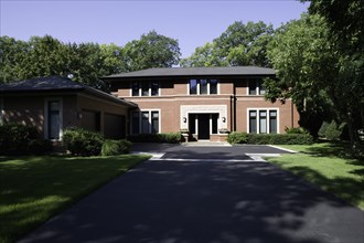Brick contemporary  Prairie style home with blacktop driveway leading  up to home