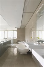 Modern bathroom with glass wall separating it from bedroom