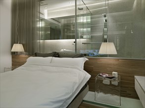 Modern bedroom with glass wall to bathroom