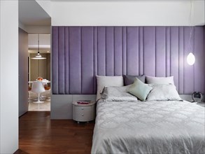 Elegant modern bedroom with purple padded wall