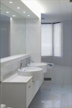 Double bowl sinks in white bathroom