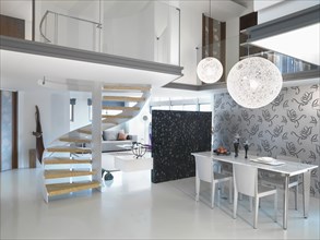 Modern dining area with winding staircase