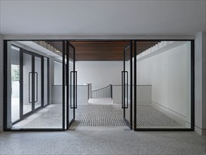 Modern entrance foyer with glass doors and stone floor