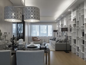 Modern dining and living room with wall length bookcase