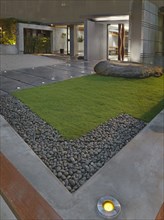 Grass and sidewalk outside front entrance of modern building