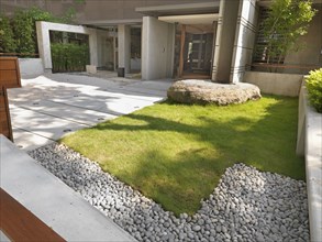 Grass and sidewalk outside front entrance of modern building