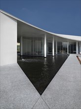 Triangular shaped pool outside modern building