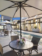 Patio table and chairs with umbrella by pool
