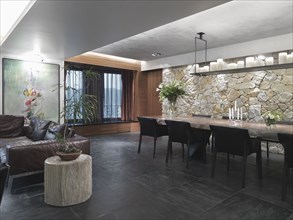 Modern great room with slate tile floor and a stone wall
