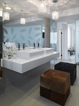Modern bathroom with double sinks and ottomans