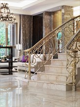 Staircase with intricate metal balusters and marble surface