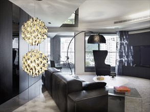 Black leather sofa and funky lamp in a modern living room