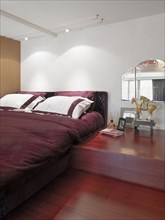 Red bed and hardwood floor in modern bedroom