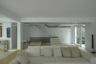 Sofa and floating staircase in modern home