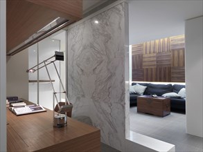 Marble wall dividing home office from living room