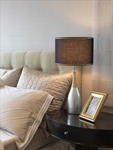 Detail lamp and nightstand beside bed