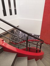Winding red staircase with handrail