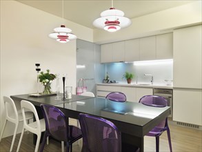 Black dining table with purple and white chairs