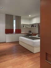 Bed in bedroom with hardwood floor