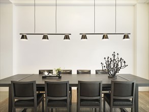 Simple dining table in modern home with hanging lights