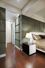Brown bed in modern bedroom with green accent wall