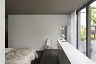 View of a cropped bed along large window in bedroom at contemporary house