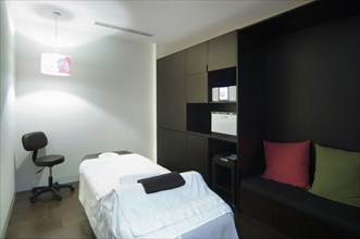 Lit lamp and massage table in spa room