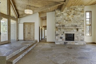 Empty interior with large stone fireplace