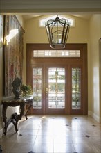 Contemporary foyer with glass front door and cathedral ceiling