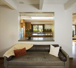 Leather Sofa in Modern Living Room with Cutout to Kitchen