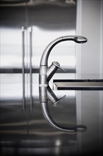 Detail of stainless steel faucet with reflection.