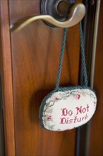 Detail of door handle with do not disturb sign.