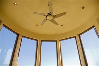 Detail of large bay windows and ceiling fan