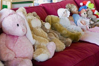 Couch full of dolls and stuffed animals