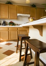 Two wooden stools at breakfast bar in kitchen