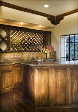 Old wet bar with wood paneling and wine rack
