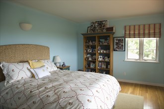 Bed with floral print comforter in blue bedroom