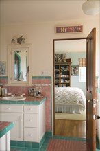 Pink and blue tiled bathroom between bedrooms