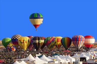 Hot air balloon floating above others at festival