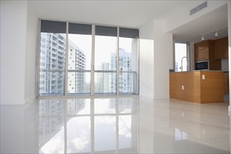 Windows and reflective floor in empty modern apartment
