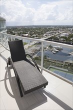 Deck chair on balcony overlooking cityscape