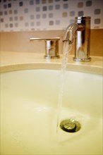 Close up of water flowing from faucet in sink