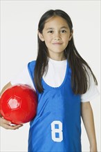 Asian girl holding soccer ball