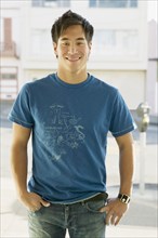 Asian man with hands in pockets