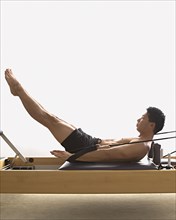Asian man stretching on exercise equipment