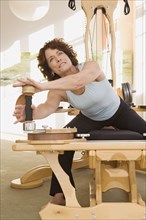 Senior woman stretching on exercise equipment