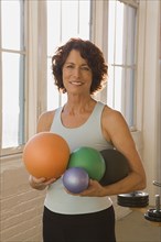 Senior woman holding exercise balls